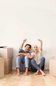 excited-couple-sitting-on-floor-discussing-future-S5E6D3A (1) huis verhuren aan expats zaandam